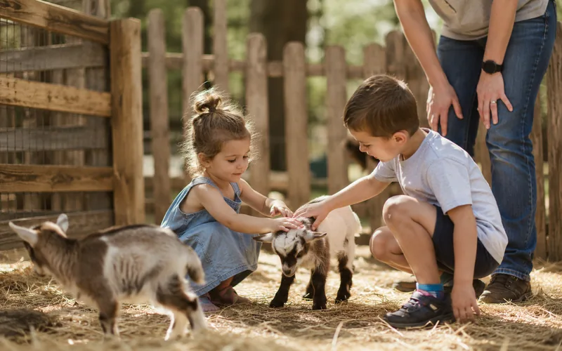 Children gently petting goats at a farm petting zoo under adult supervision